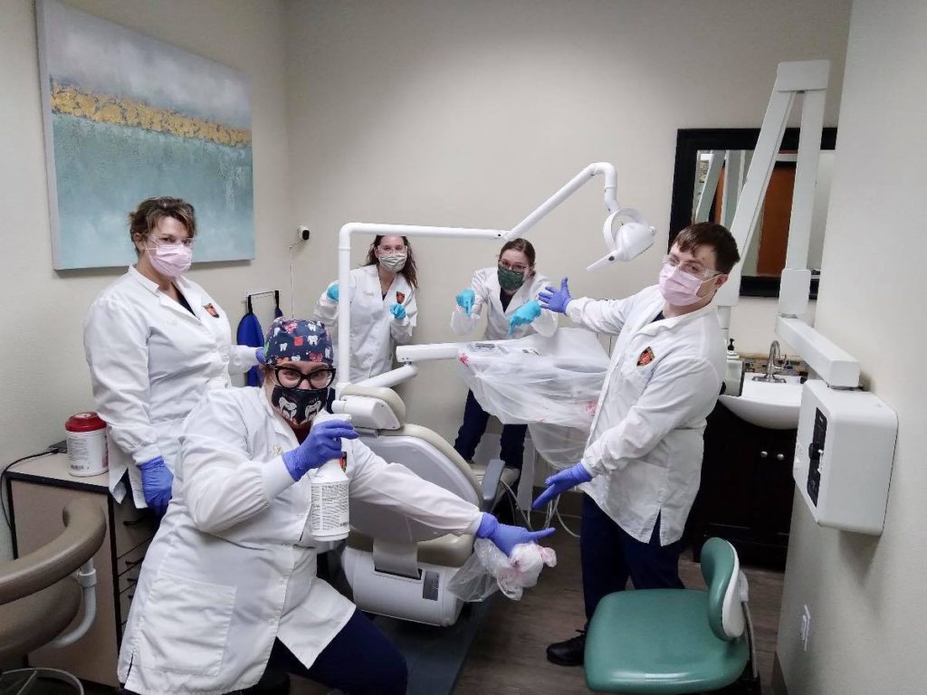 A group of people in lab coats and masks.