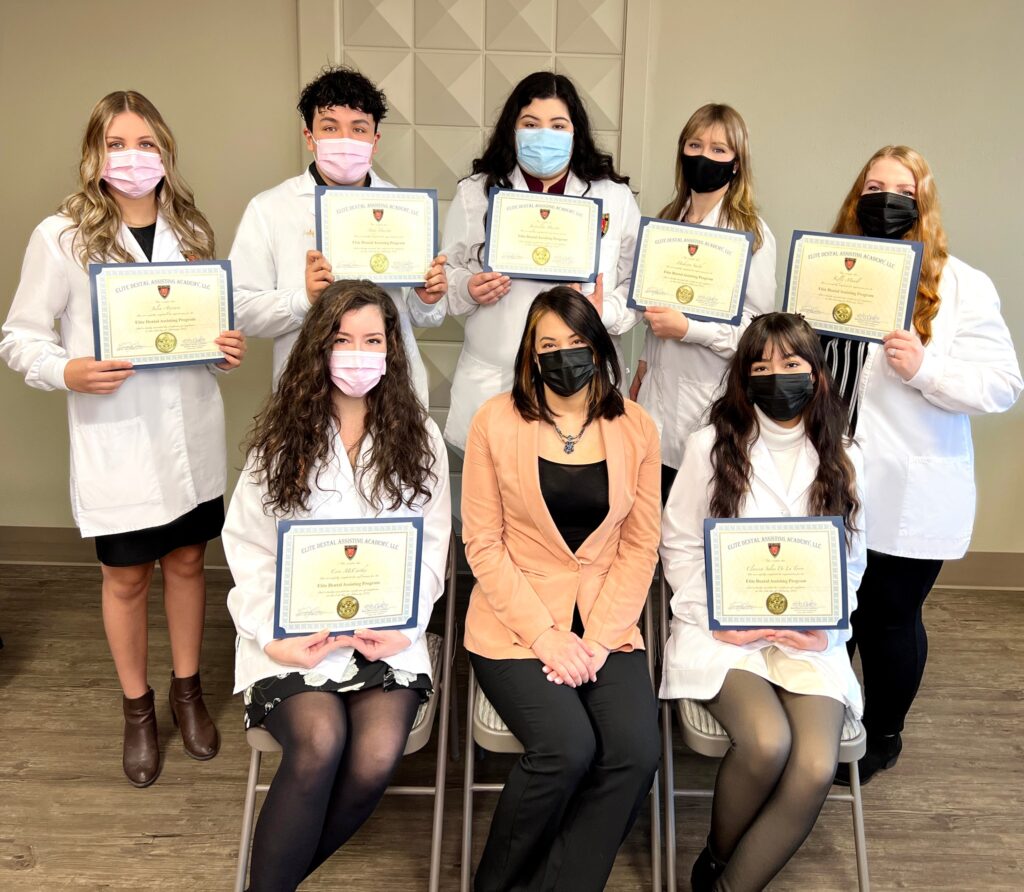 A group of people in lab coats and masks holding certificates.