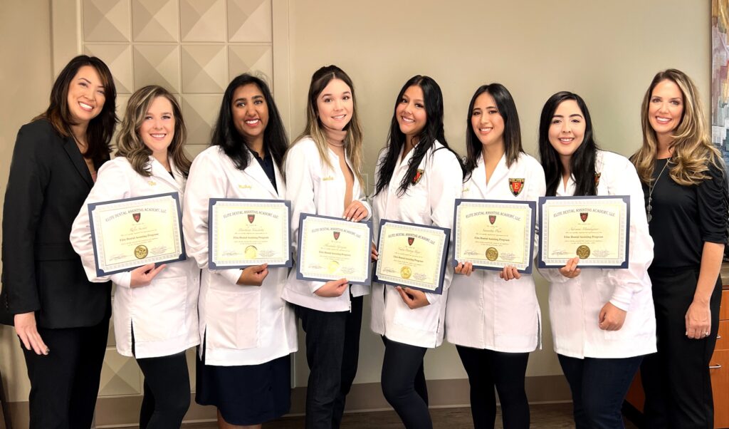 A group of women in lab coats holding certificates.