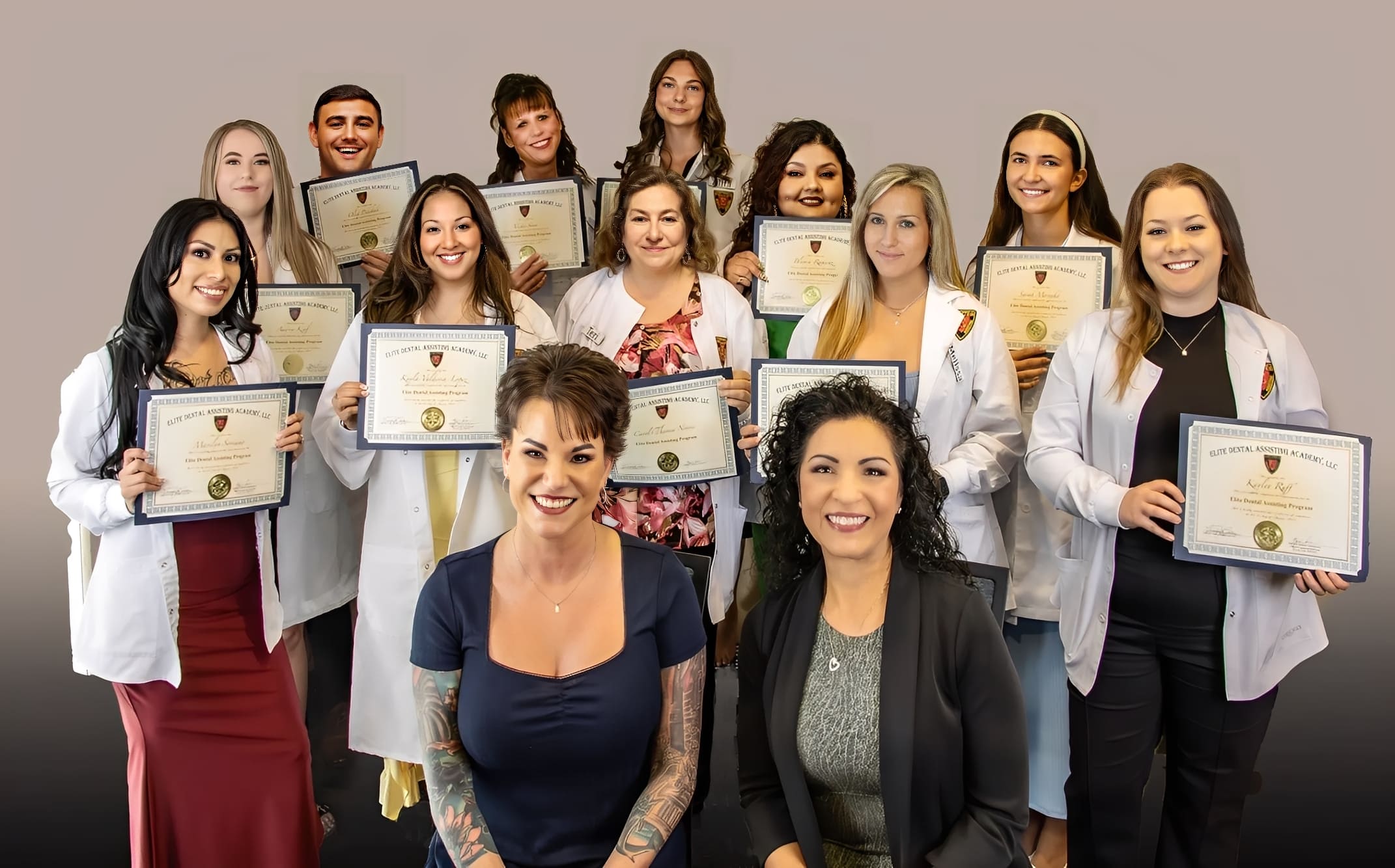 Group of graduates holding certificates, smiling.