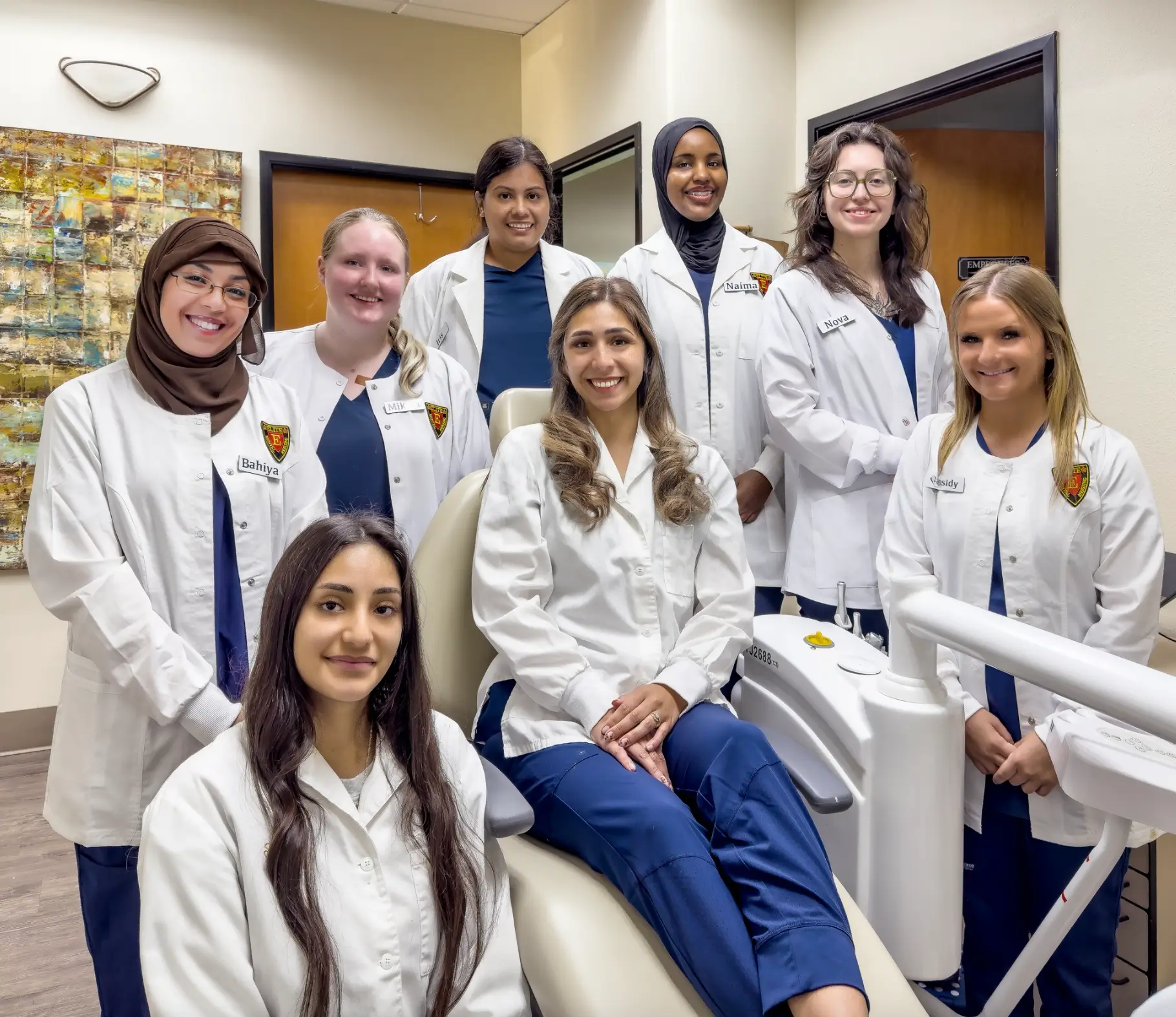 Group of women in medical uniforms smiling.